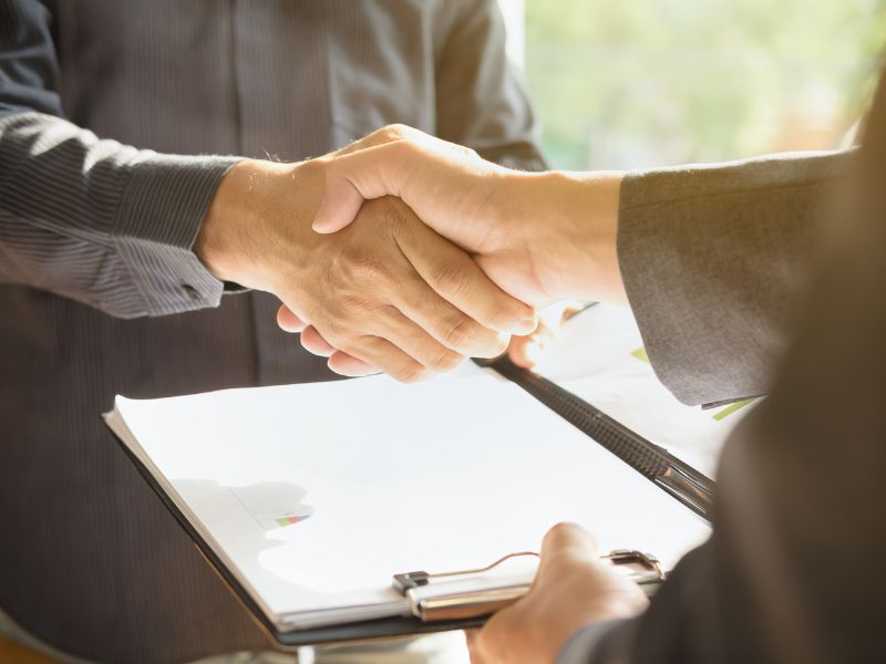 stretta di mano davanti a contratti